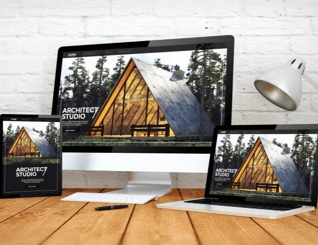 A tablet, desktop computer, and laptop all side-by-side, displaying the same website, to demonstrate responsive web design