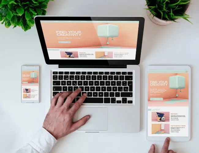 A phone, laptop, and tablet laid out on a desk, with the same website, to demonstrate what is responsive web design