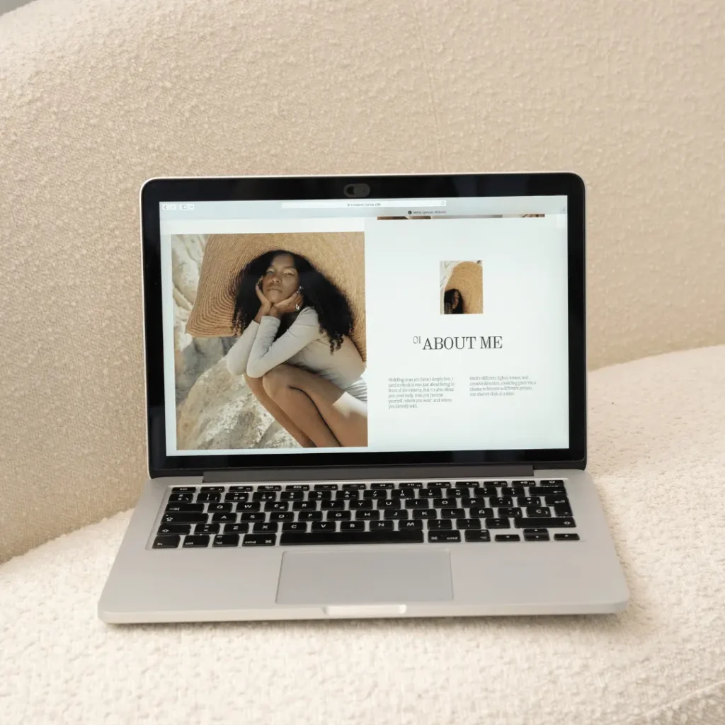 A laptop displaying an "About Me" webpage that uses white space well