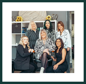 A smiling team of women from Region Accountancy posing together in a relaxed office setting.