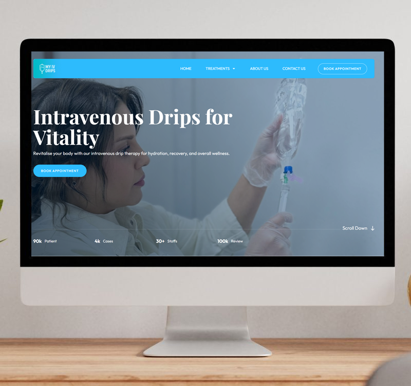 A desktop monitor displaying the My IV Drips website homepage, featuring a medical professional preparing an intravenous drip and buttons to book appointments for vitality and wellness.