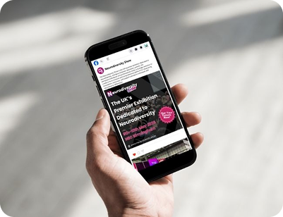A person's hand holding a smartphone displaying a Facebook post for the Neurodiversity Show, featuring an event advertisement for May 2026 at the NEC Birmingham.