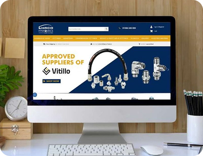A desktop monitor showing the HRCO Hydraulics e-commerce site, highlighting Vitillo brand hydraulic fittings and hoses.