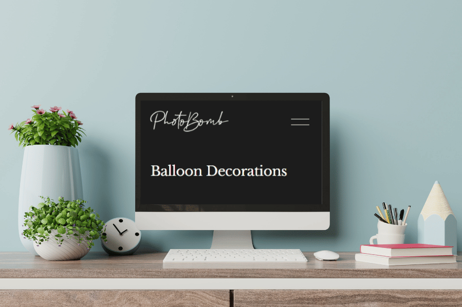 Desktop computer displaying a balloon decoration website on a tidy workspace.