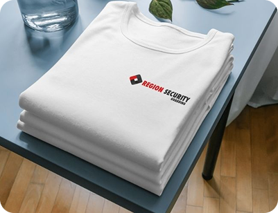 Stack of white T-shirts with Region Security logo.