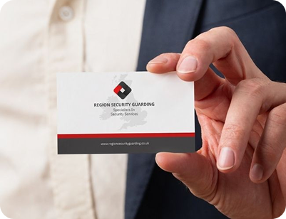 Hand holding a business card for a security company.