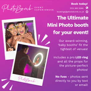 Mini photo booth at an event showing guests smiling and posing with props under a bright LED ring light.