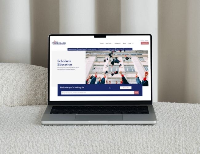 Laptop displaying an education website on a neutral sofa.