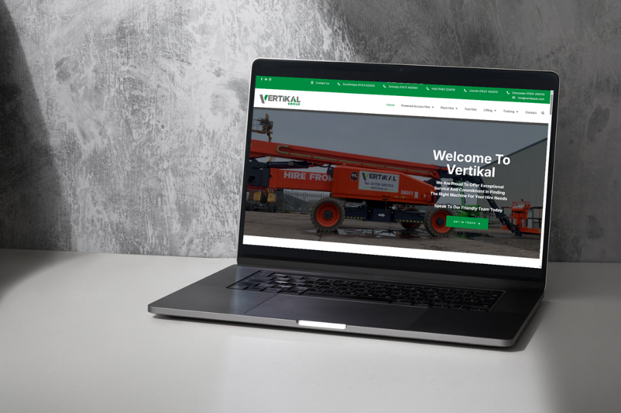 Desktop computer displaying the Vertikal Group construction equipment website, representing construction company marketing and industry-focused website design solutions for trade and hire businesses.