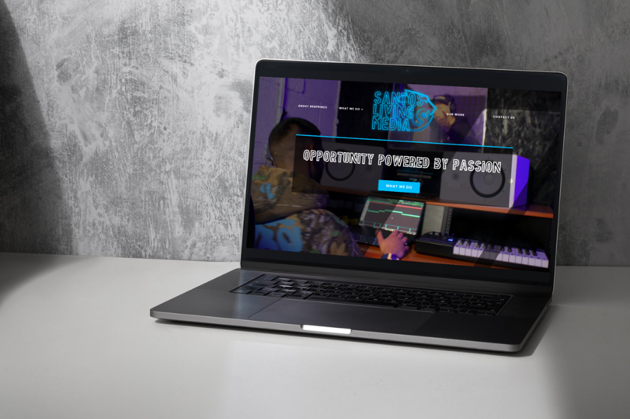 Desktop computer displaying the Santos Living Media website, representing industry-focused marketing and digital website design solutions for creative media and entertainment brands.