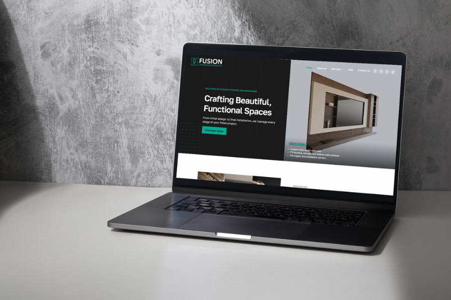 Desktop computer displaying the Fusion Kitchens and Bedrooms Ltd website, representing construction company marketing and industry-focused website design solutions for kitchen, bedroom, and interior design businesses.