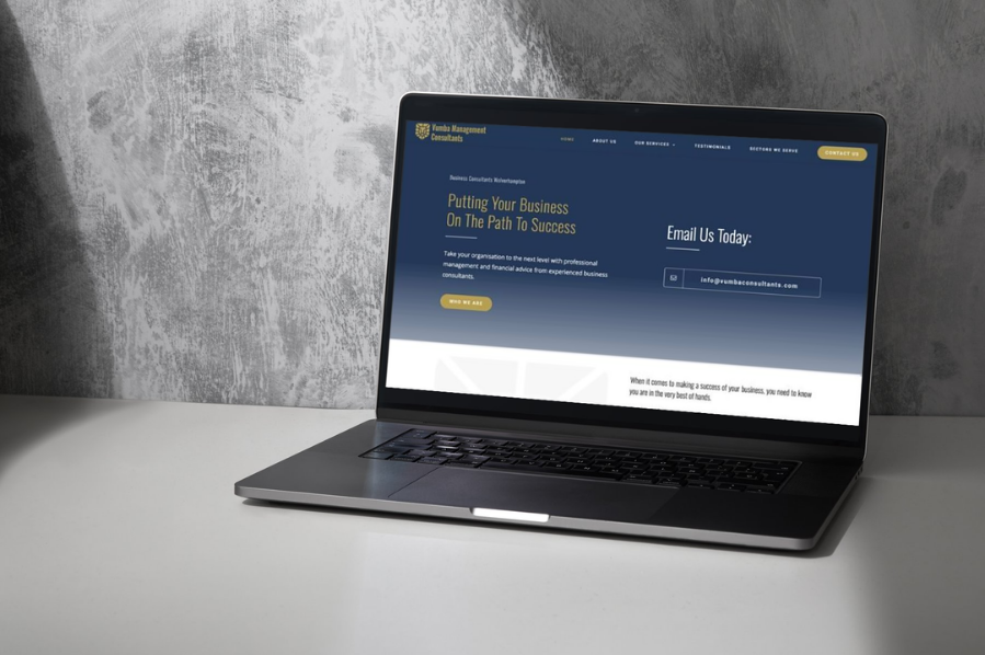 Desktop computer displaying the Yumba Management Consultants website, representing industry-focused marketing and professional website design solutions for consultancy and business services.