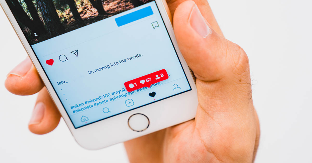 Person using Instagram on a smartphone, showing social media engagement through likes and comments.